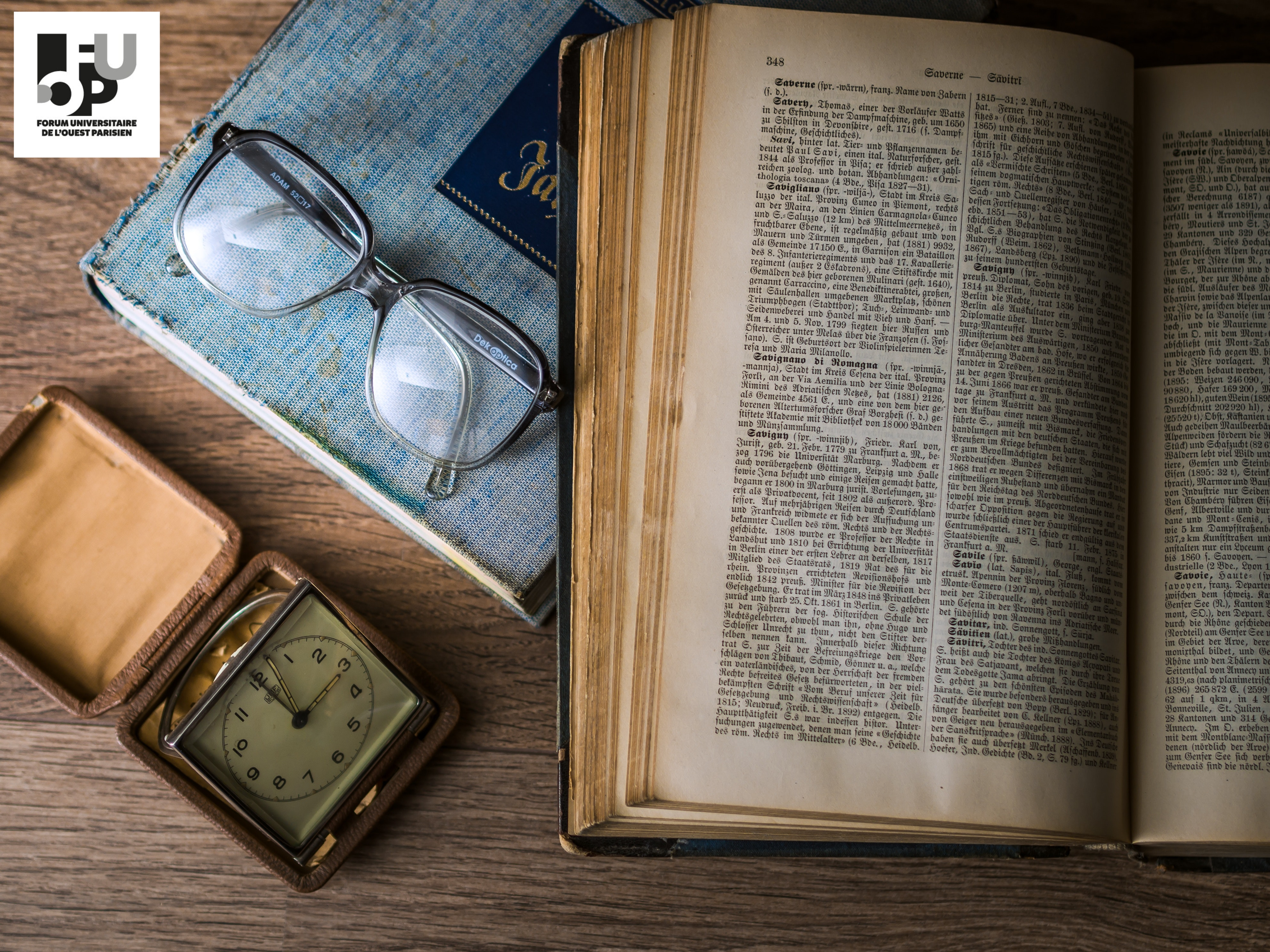 Un livre ouvert, une paire de lunette et une horloge