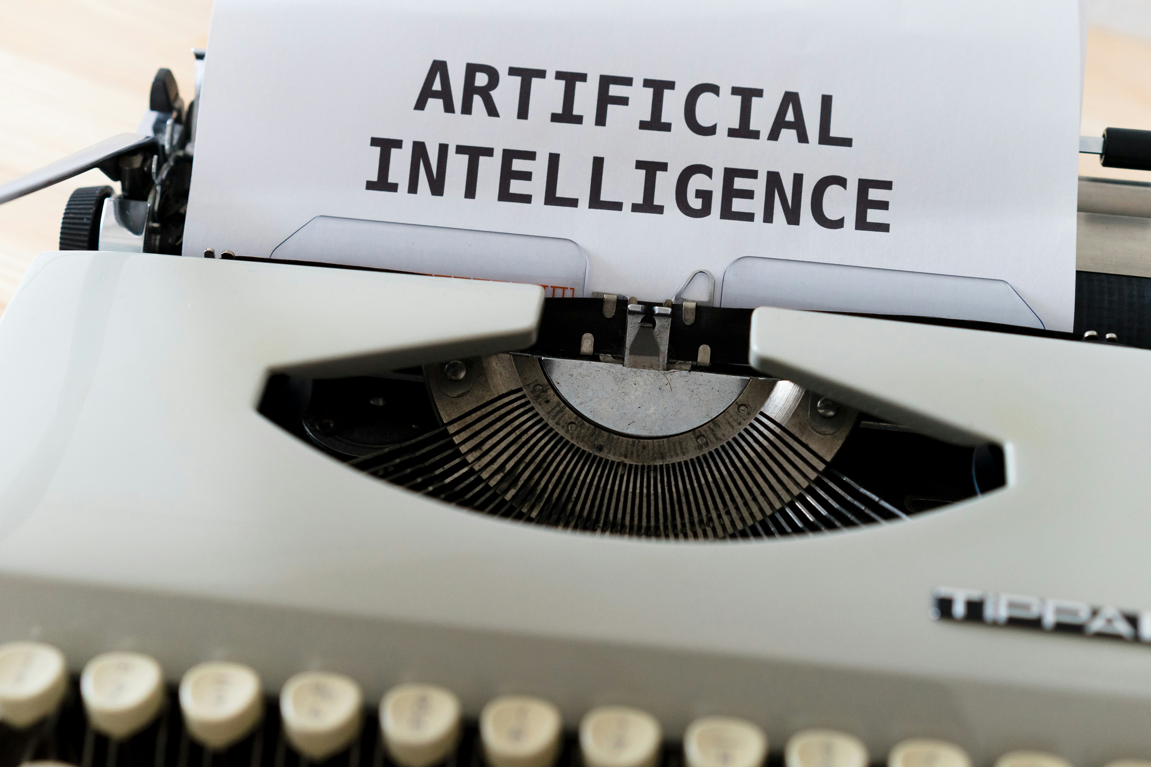 image de présentation de la session représentant une machine à écrire avec le texte "artificial intelligence" tapé sur une feuille