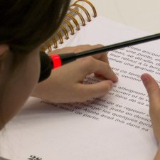 Gros plan des mains d'une fille en train de lire en braille