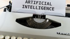 image de présentation de la session représentant une machine à écrire avec le texte "artificial intelligence" tapé sur une feuille